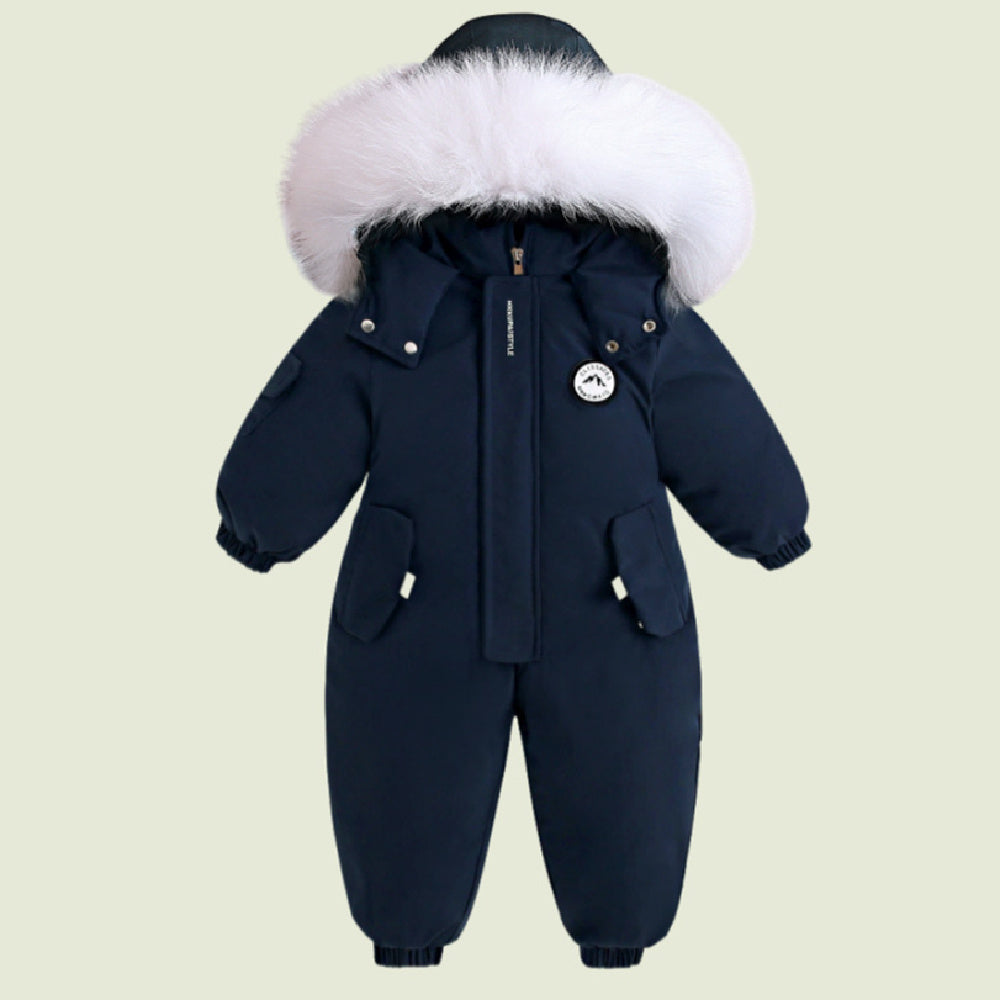 Navy blue baby snowsuit with white fur hood on a beige background
