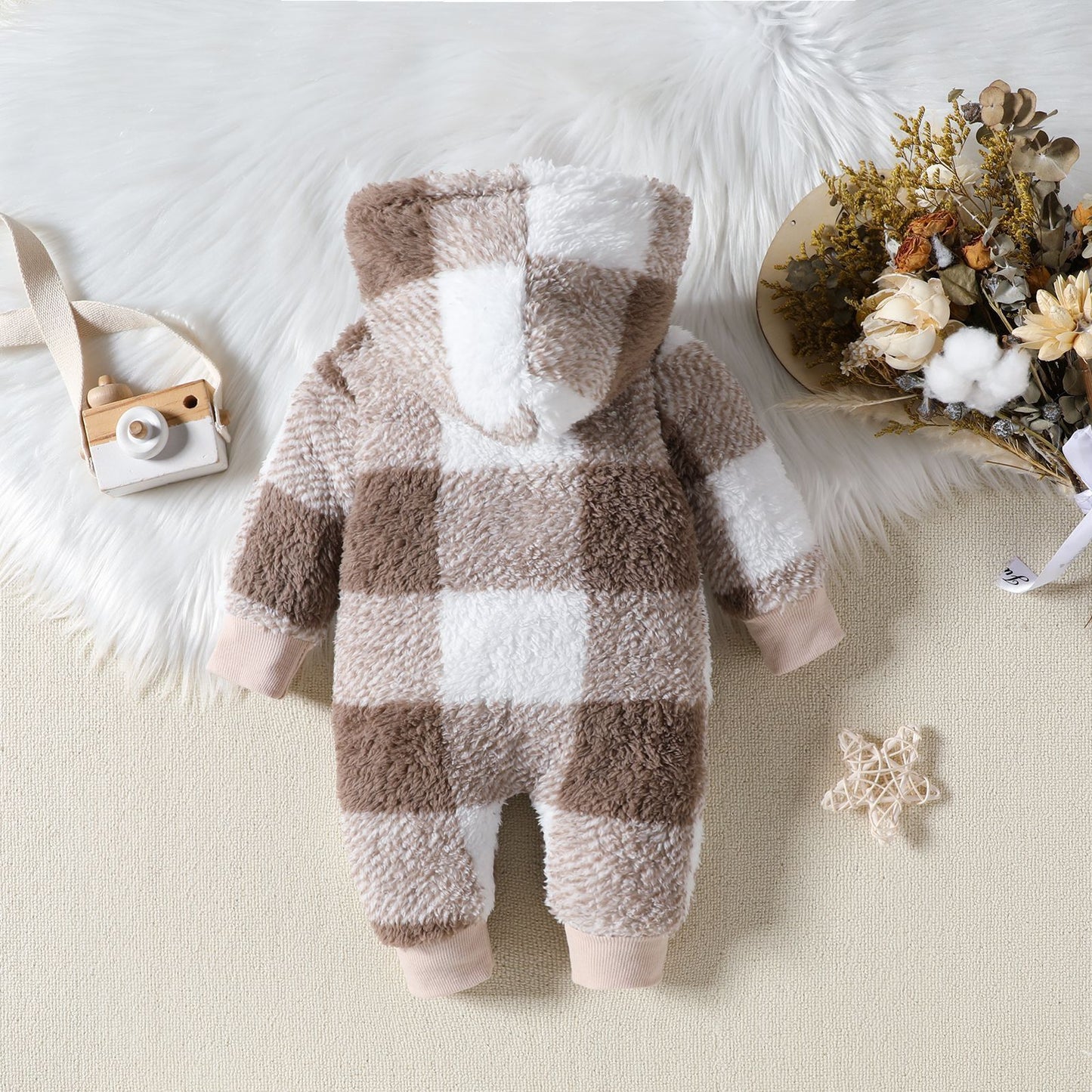 Plaid baby onesie with checkered pattern on a light background