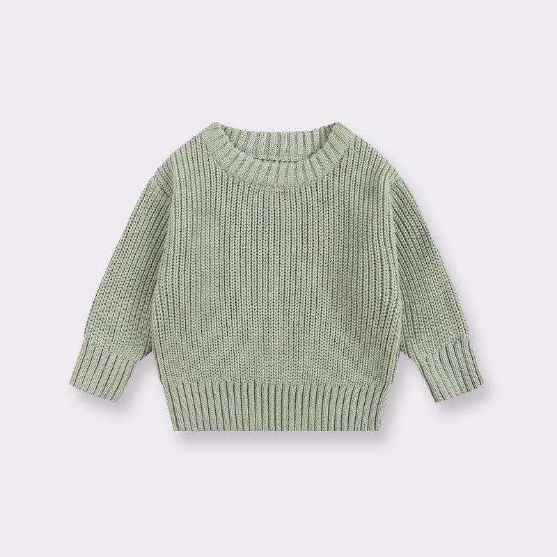 Green knitted sweater on a light gray background