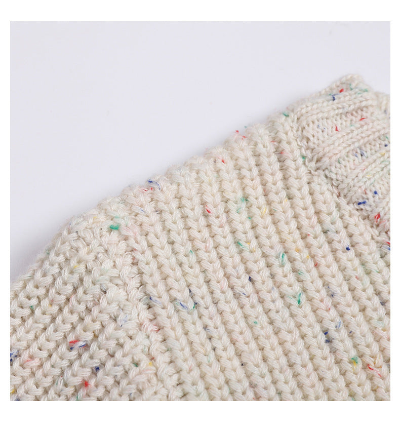 Close-up of a textured knitted fabric with colorful specks on a white background