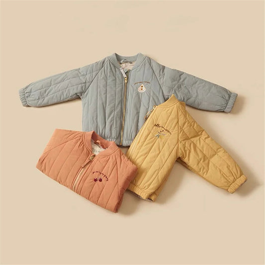 Three children's quilted jackets in blue, orange, and yellow on a beige background