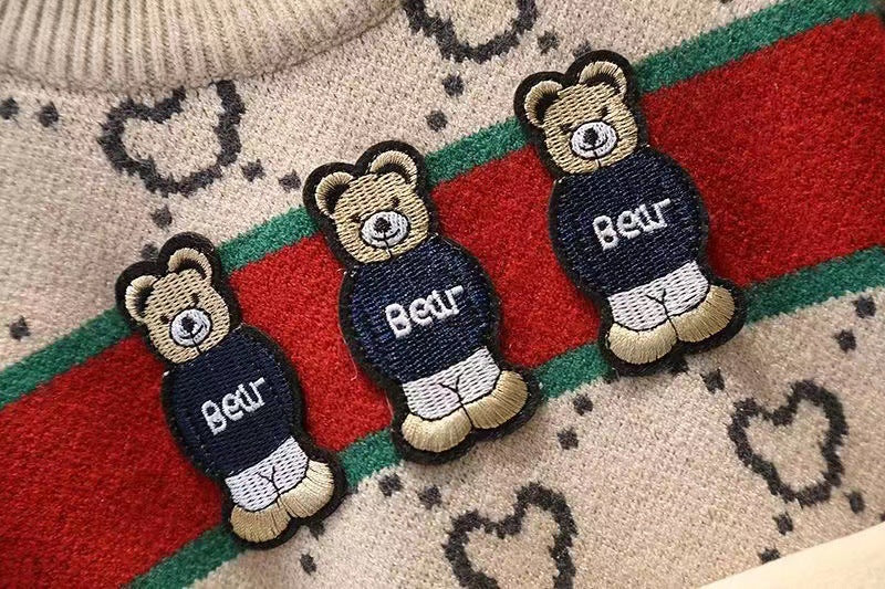 Three teddy bear-shaped patches with 'Bear' text on a patterned fabric background
