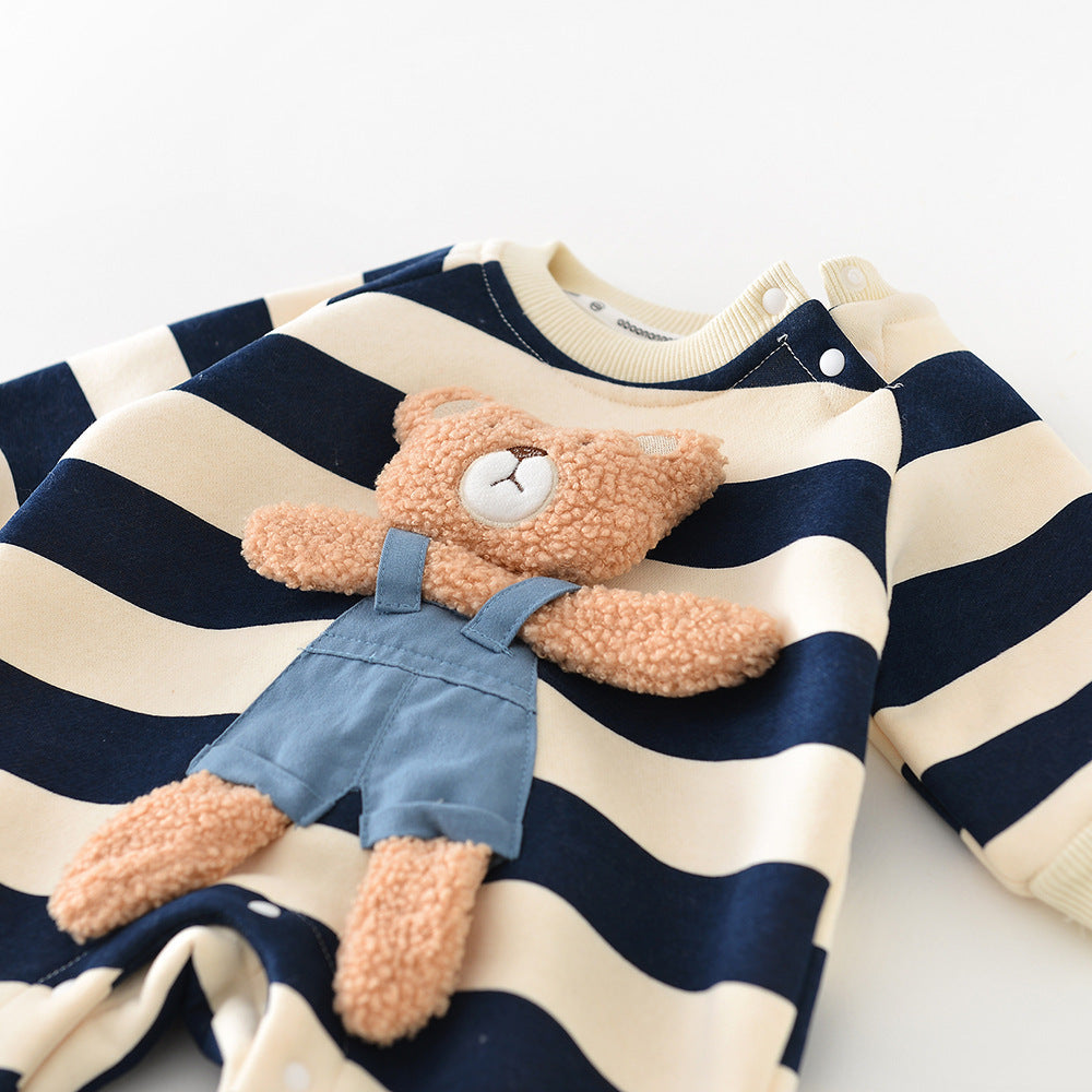 Plush teddy bear in denim overalls on a navy and white striped shirt