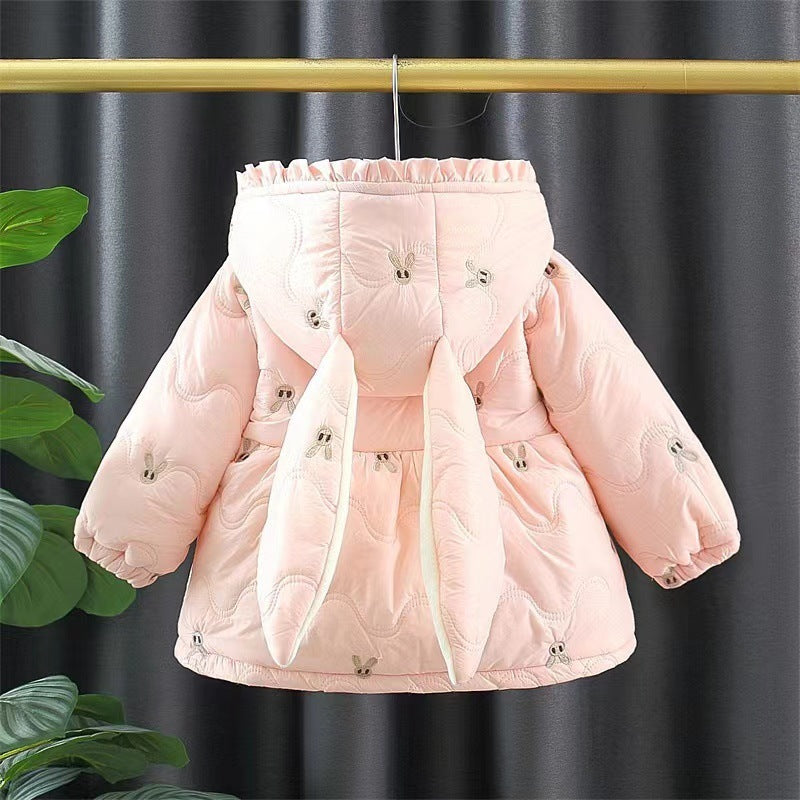 Pink puffer jacket on a hanger against a dark curtain background