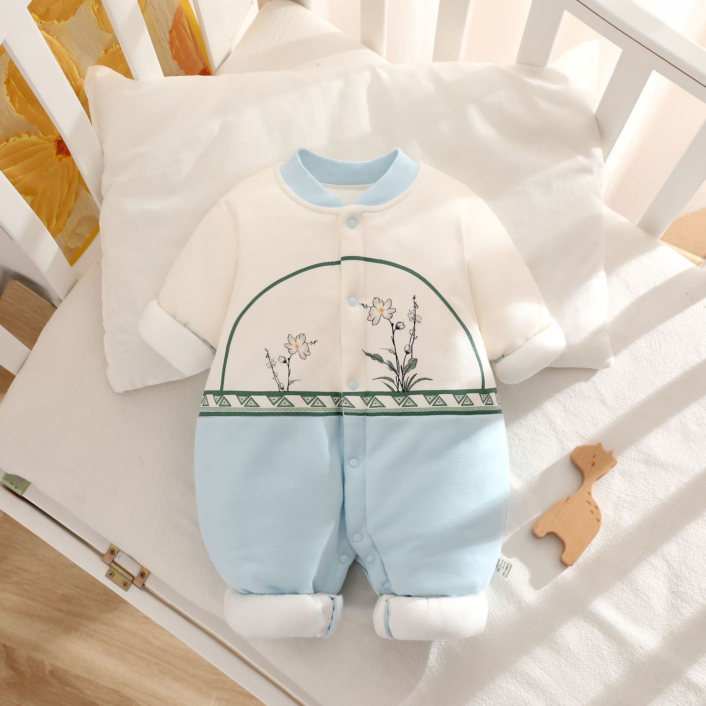 Baby romper with floral design on a crib