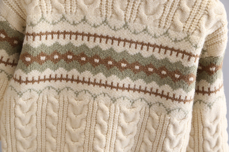 Close-up of a cable knit sweater with a patterned design.