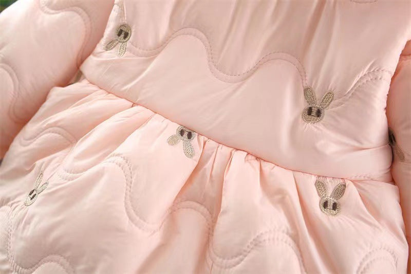 Close-up of a pink quilted jacket with decorative buttons.
