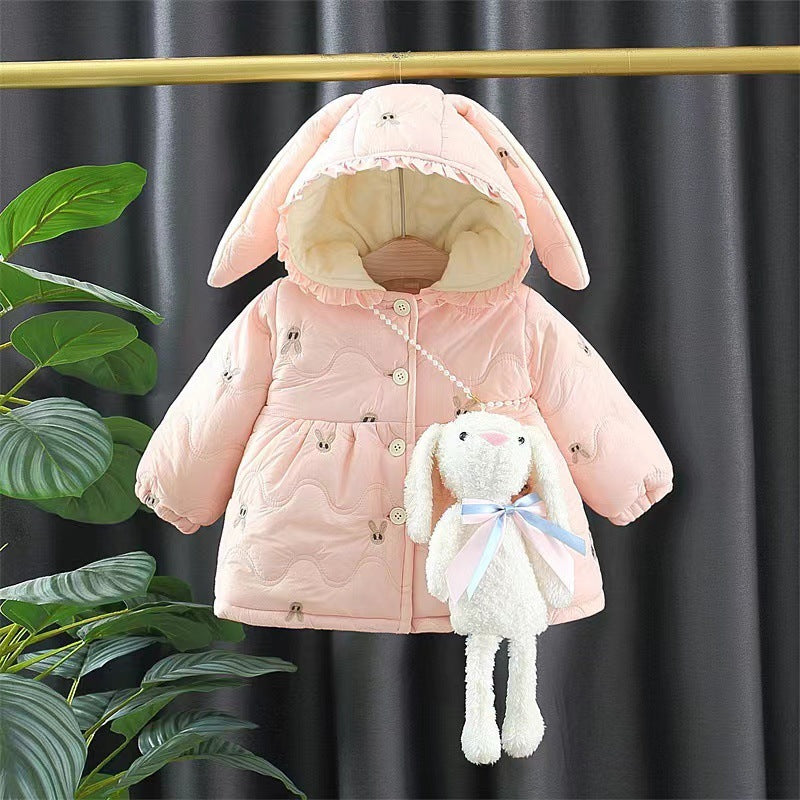 Pink children's coat with bunny ears and a plush toy on a dark background