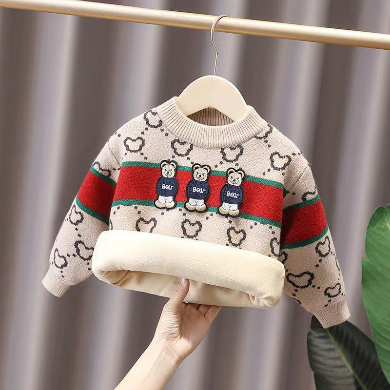 Children's sweater with bear design on a hanger against a neutral background